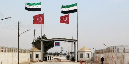 A Turkish-Syrian checkpoint seen from the Syrian side.  Note the colors of the four horsemen.